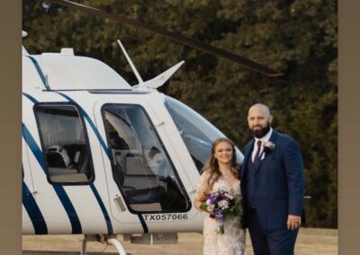 bridal couple in front of helicopter