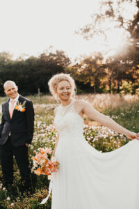 Newlyweds in a meadow surrounded by wildflowers